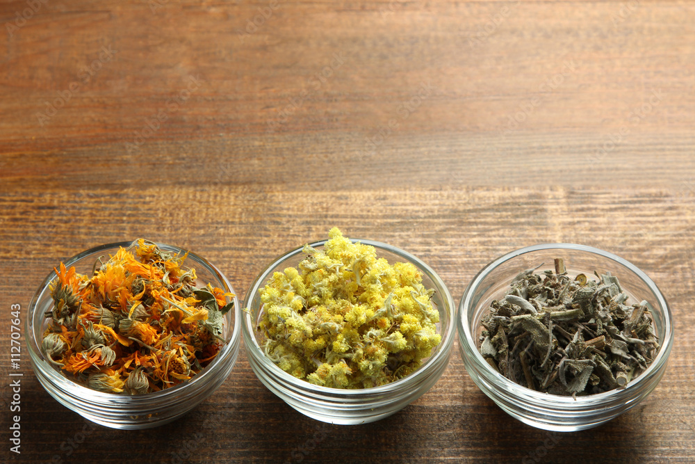 dried flowers dried herbs in glass bowl on wooden brown background dried flowers dried herbs in glass bowl on wooden brown background