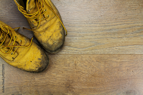 Muddy work boots on a wooden floor