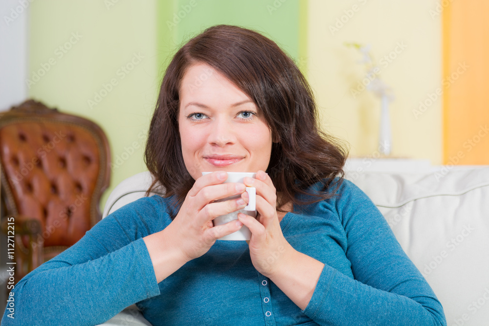frau genießt einen tee auf dem sofa frau genießt einen tee auf dem sofa