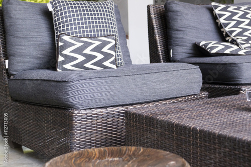 black, white cushion and pillow on wicker chair