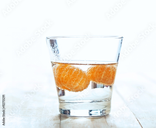 infusioned water of oranges in the glass on wooden background