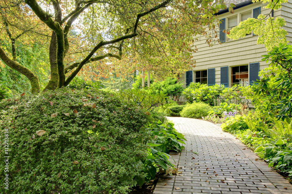 Small American home with light exterior and a large grass filled lawn