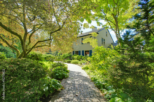 Small American home with light exterior and a large grass filled lawn