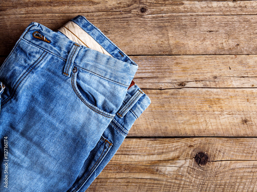 Jeans on a wooden background. The upper part. Clothing, fashion,