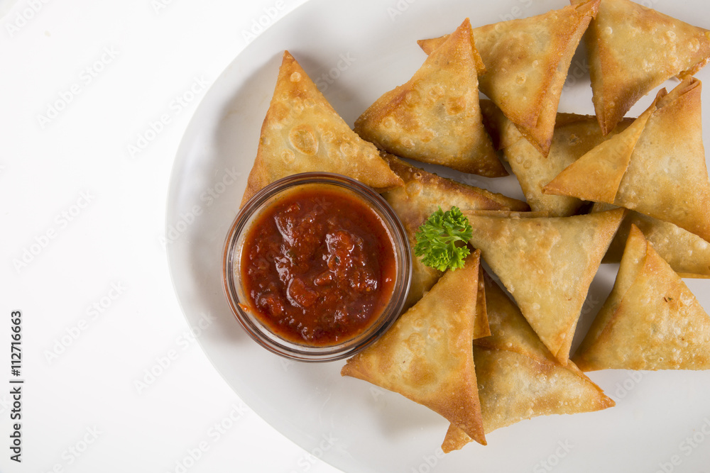 Cape Malay Samoosas on white plate served with Atjar sauce. Cape Malay Samoosas on white plate served with Atjar sauce.