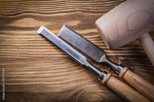 Wooden hammer chisels on vintage wood board construction concept