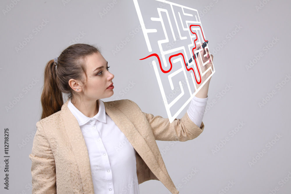 Young woman finding the maze solution, writing on whiteboard. Young woman finding the maze solution, writing on whiteboard.