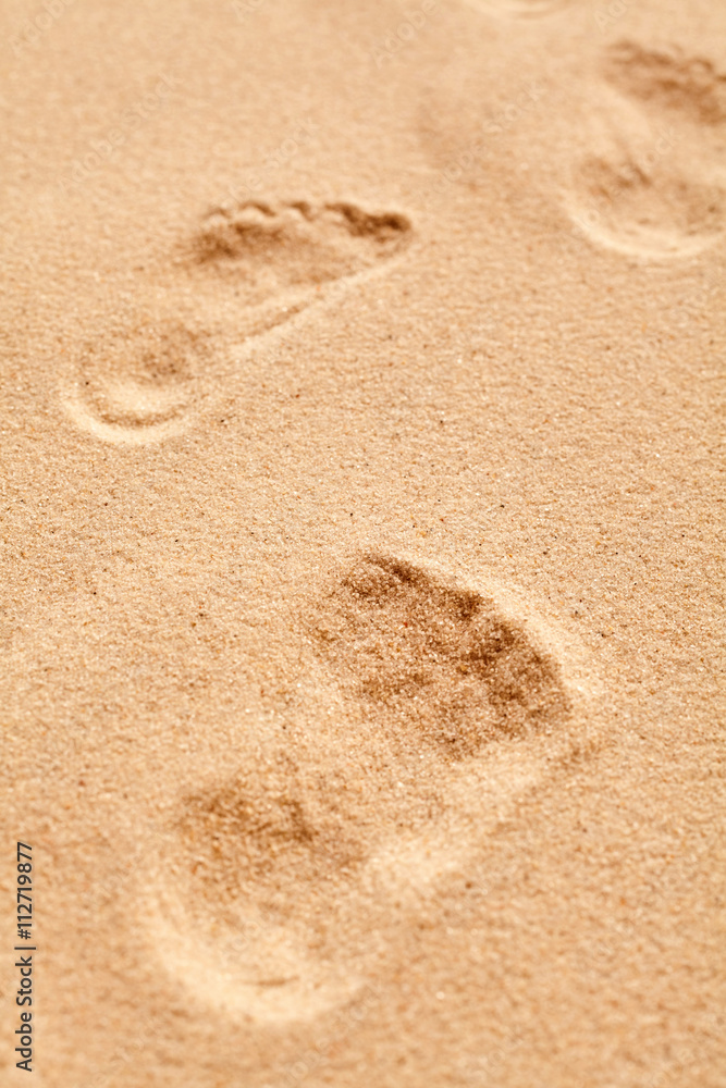 Close up on a bare footprint in granular sand Close up on a bare footprint in granular sand
