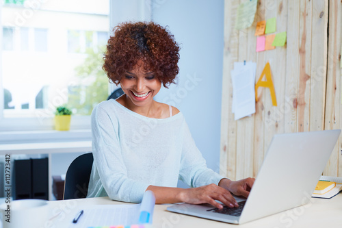 Fotografija Attractive young woman working at desk with her laptop and docum