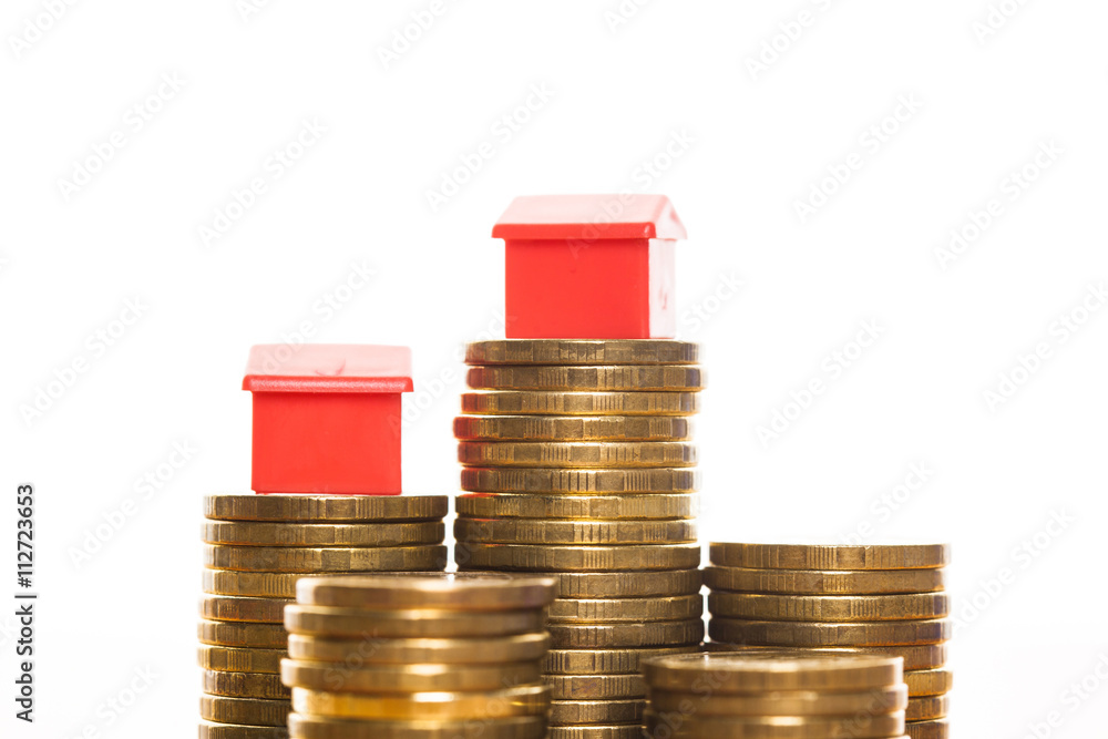 Stacks of coins, green and red home. Mortgage concept by money house from coins Stacks of coins, green and red home. Mortgage concept by money house from coins