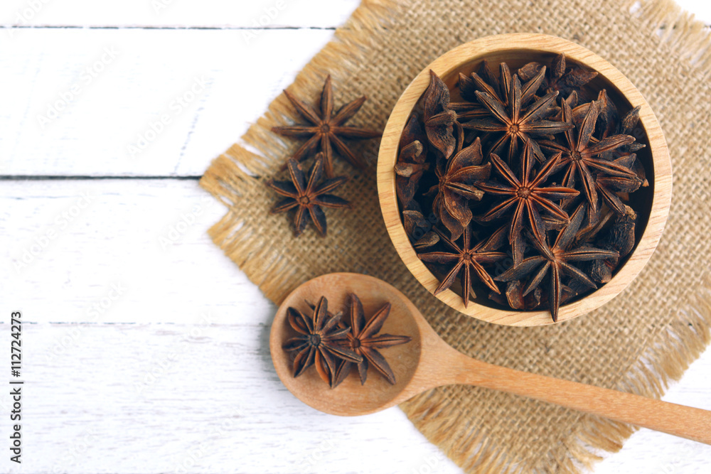 star anise in wooden bowl and star anise on spoon. star anise in wooden bowl and star anise on spoon.