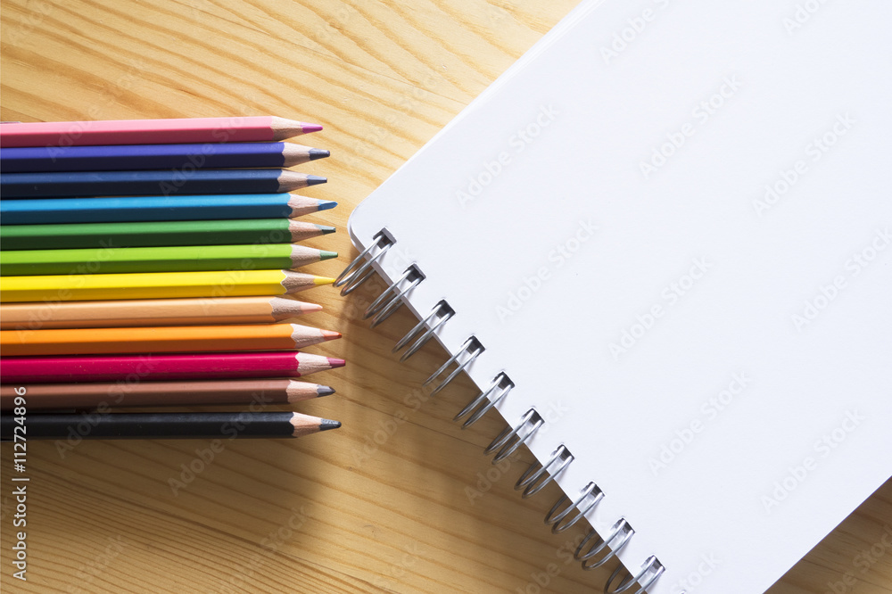 Color pencils and white paper note with wood background Color pencils and white paper note with wood background