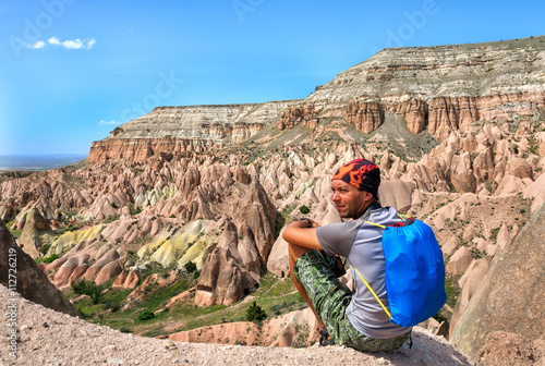 young man sits on edge of canyon in Cappadocia. Turkey
