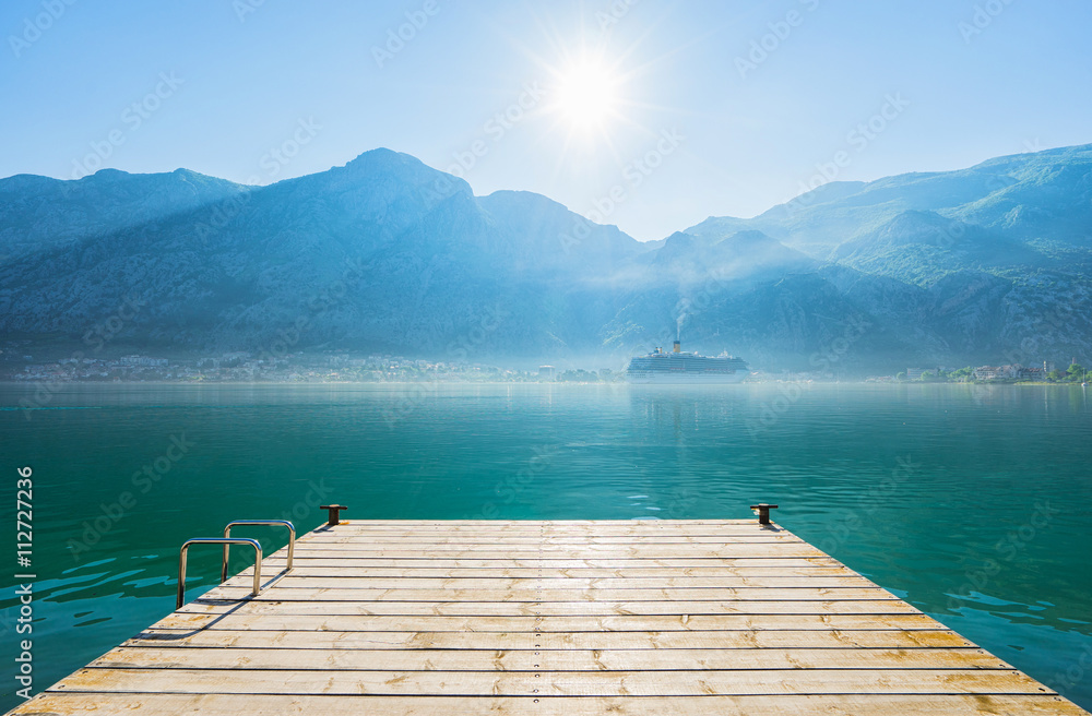 Early misty morning on the pier  with sea, Kotor city  and mountain views. Kotor bay. Montenegro
