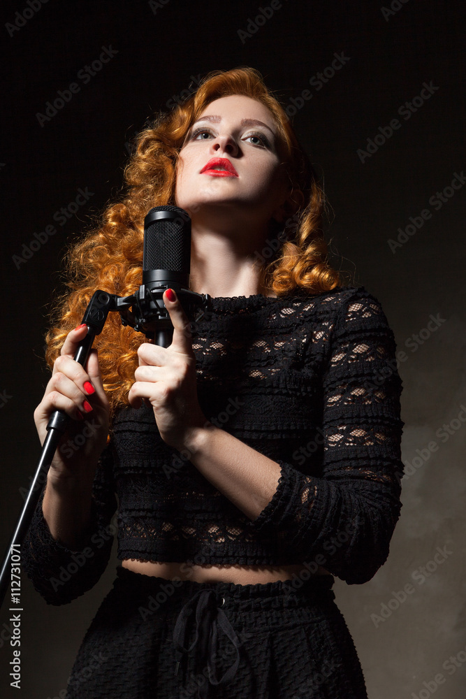 Portrait of curly-haired singer with red lips holding mic Portrait of curly-haired singer with red lips holding mic