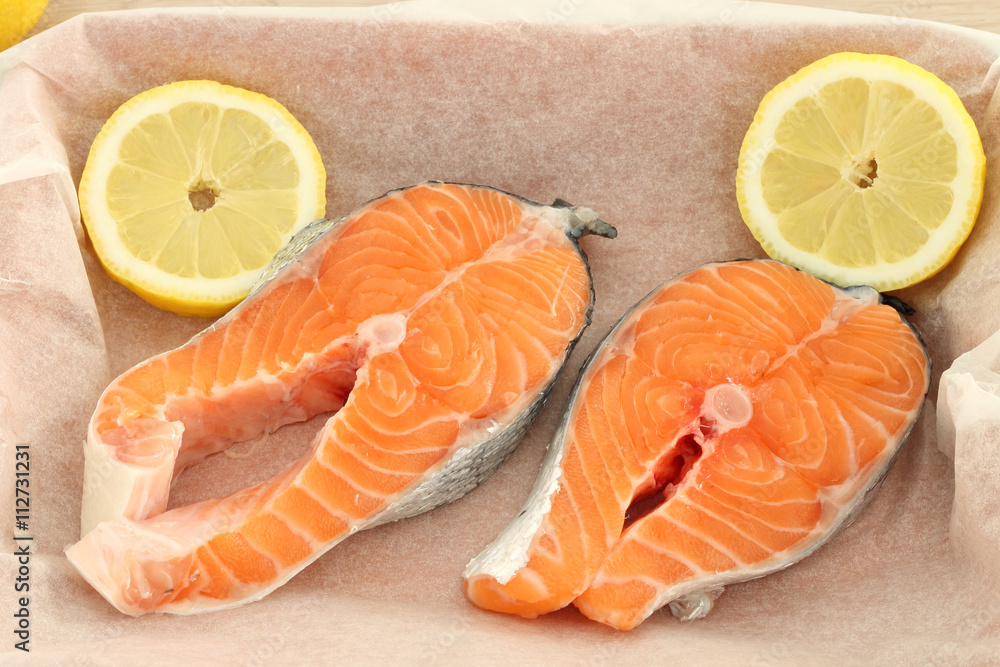 Raw fresh salmon steaks on baking paper Raw fresh salmon steaks on baking paper