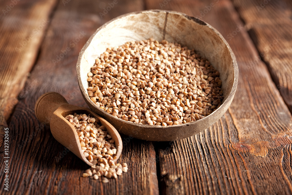 Buckwheat in scoop and bowl on wooden table Buckwheat in scoop and bowl on wooden table