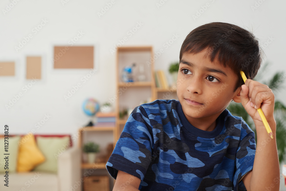 Portrait of cute Indian boy thinking over ideas Portrait of cute Indian boy thinking over ideas