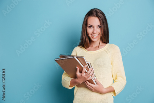Obraz na plátně Portrait of beautiful young brunette with notebooks