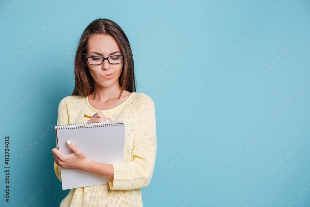 Serious young girl making notes in the notebook Serious young girl making notes in the notebook