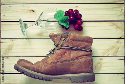 grape and glass and boots on wood back ground.effcet vintage sty photo