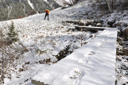 traces de pas sur passerelle enneigée d'un randonneur en montagne