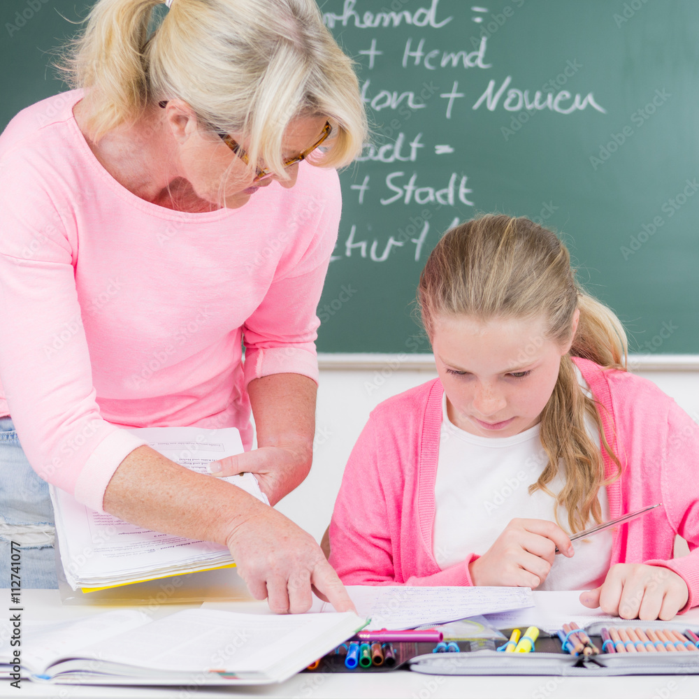 lehrerin erklärt einer schülerin aufgaben