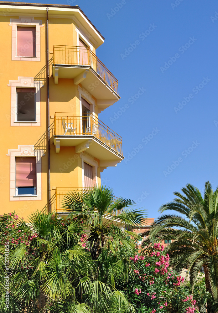 immeuble avec balcons et jardin exotique sous ciel bleu immeuble avec balcons et jardin exotique sous ciel bleu