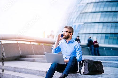 Photography Manager with laptop and smart phone, London City Hall