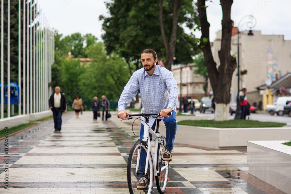 young hipster man with fixed gear bike on city street