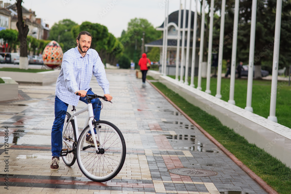 young hipster man with fixed gear bike on city street