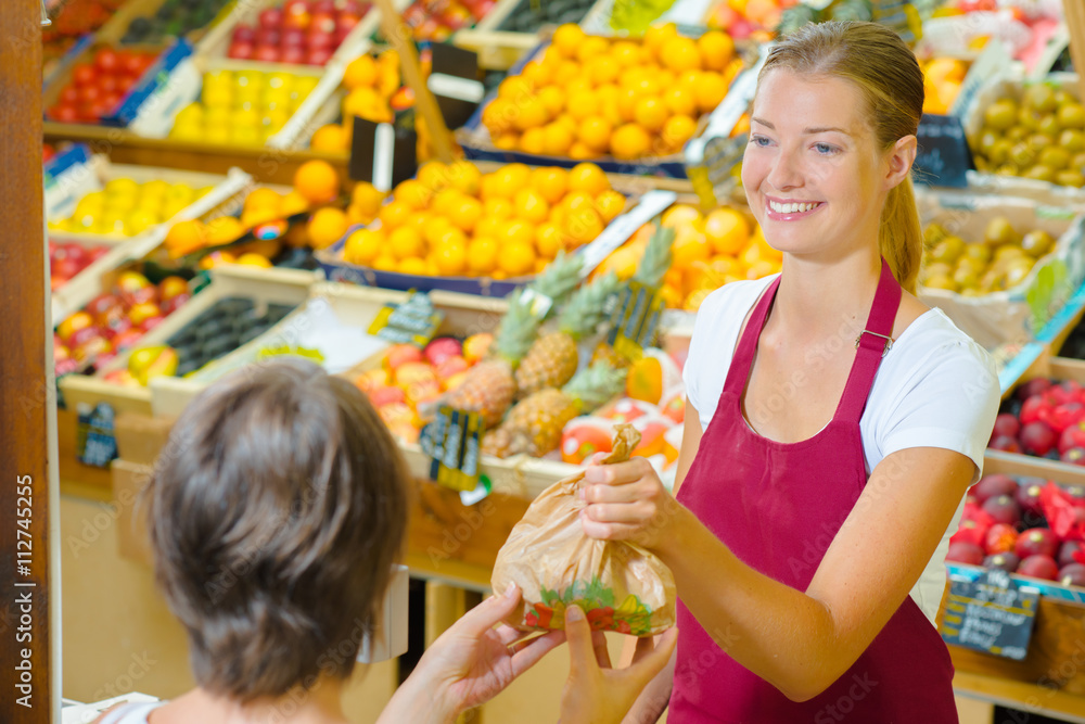 Greengrocer serving a customer Greengrocer serving a customer