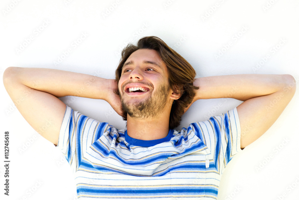 Handsome young man smiling with hands behind head Handsome young man smiling with hands behind head