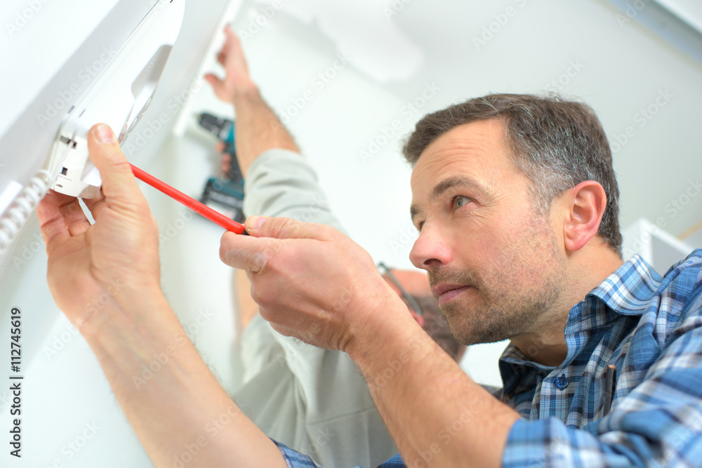 Builder installing an intercom Builder installing an intercom