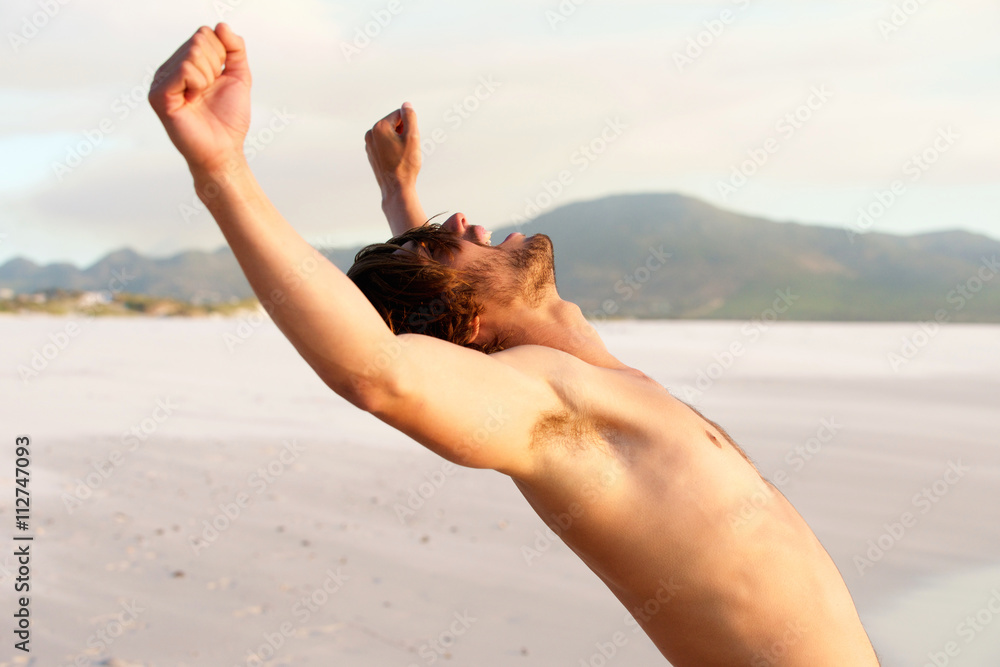 Shirtless young man with arms raised
