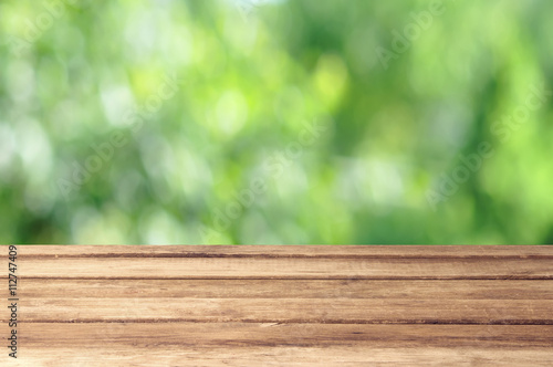 Empty wooden table with garden bokeh outdoor theme background