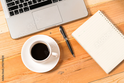 Spiral Notebook  pen and cup of coffee on laptop keyboard  