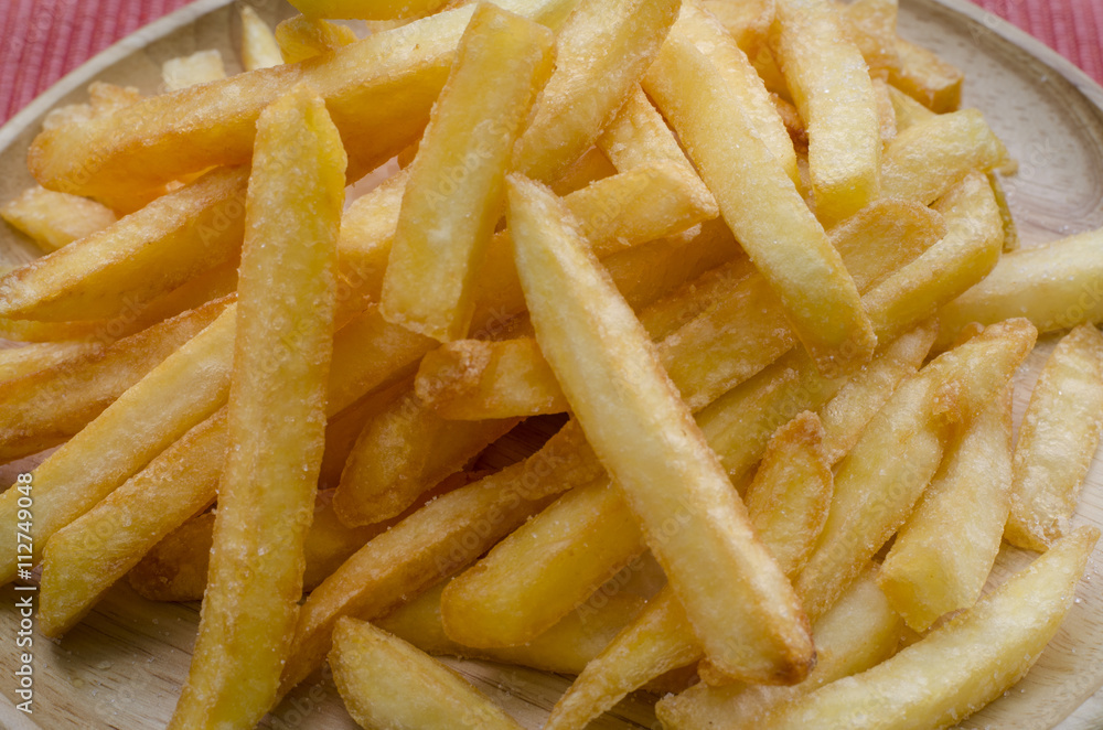 French fries sprinkled salt on wood plate French fries sprinkled salt on wood plate