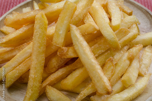French fries sprinkled salt on wood plate