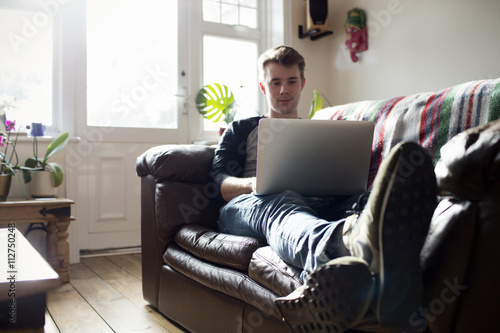 Young Man Using Laptop At Home