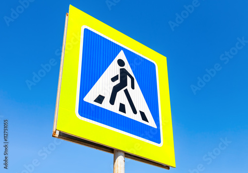 Traffic sign pedestrian crossing with blue sky in background