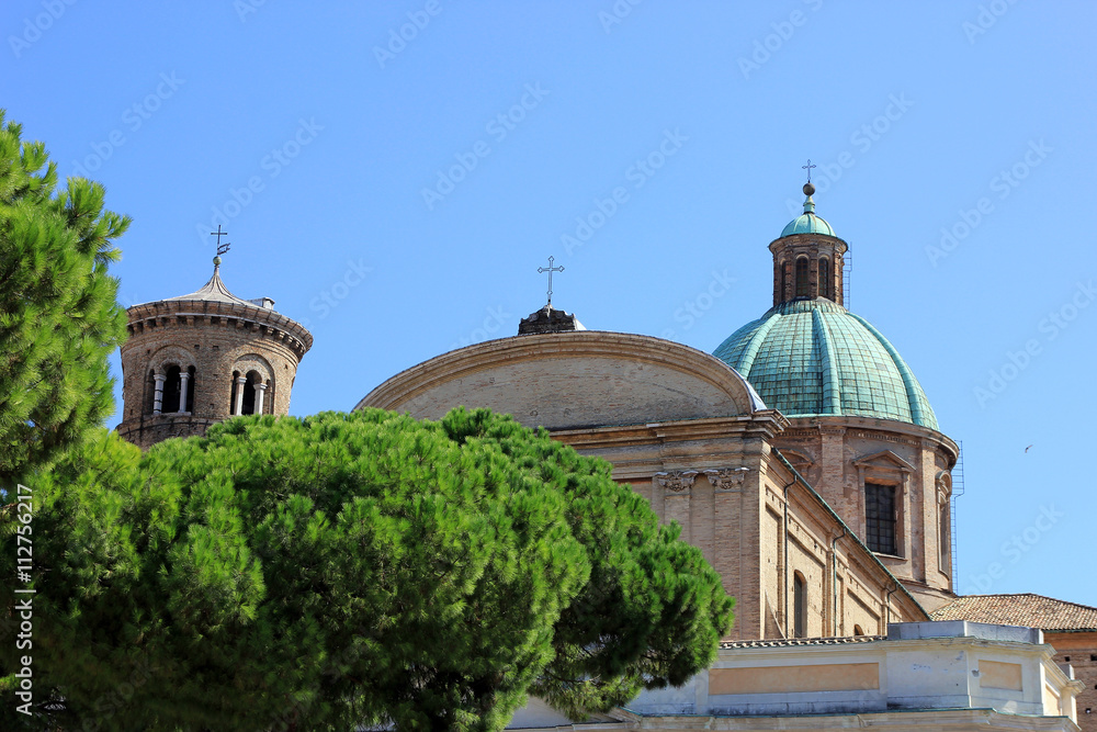 view of italian catholic roman cathedral in ravenna behind green