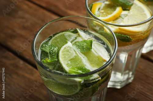 Fresh cocktails with soda, lime, lemon on a wooden background