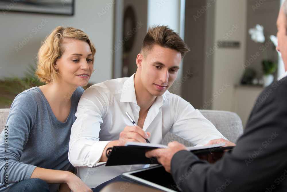 Fototapeta premium couple in real-estate agency signing with construction planner