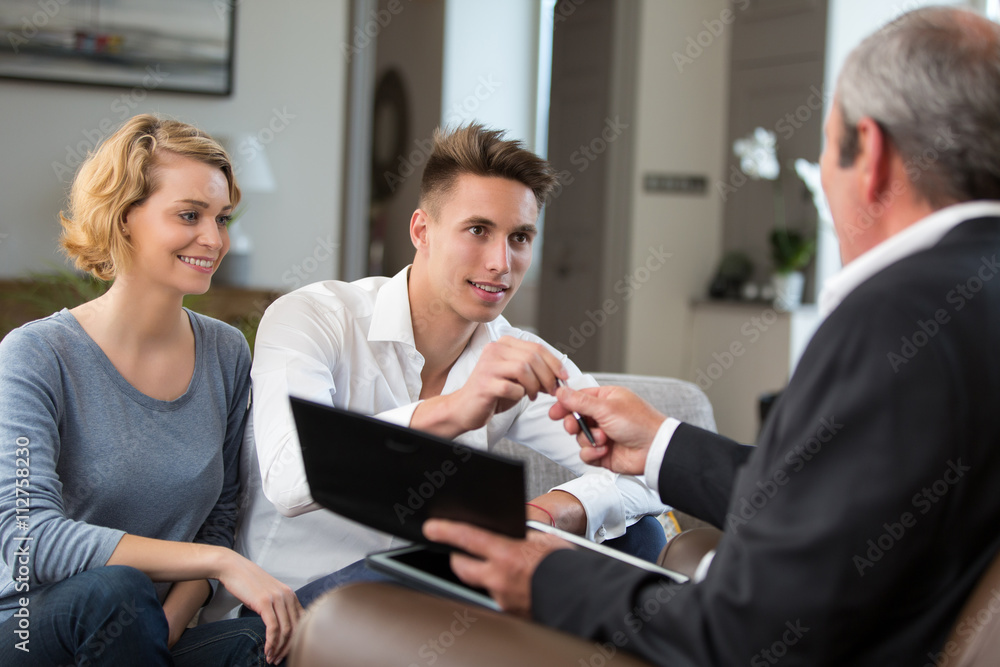 couple in real-estate agency signing with construction planner couple in real-estate agency signing with construction planner