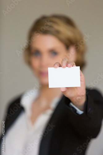 businesswoman holding blank visit card in office