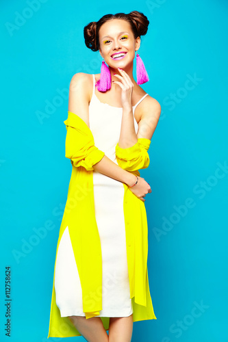 portrait of cheerful fashion hipster girl in casual colorful vivid hipster yellow summer clothes on blue background