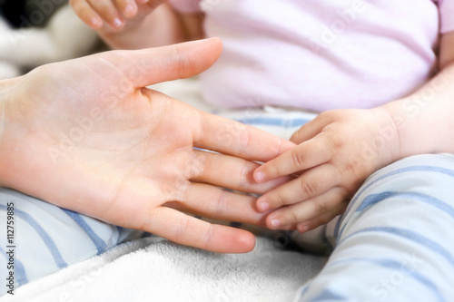 Woman holding small baby hand
