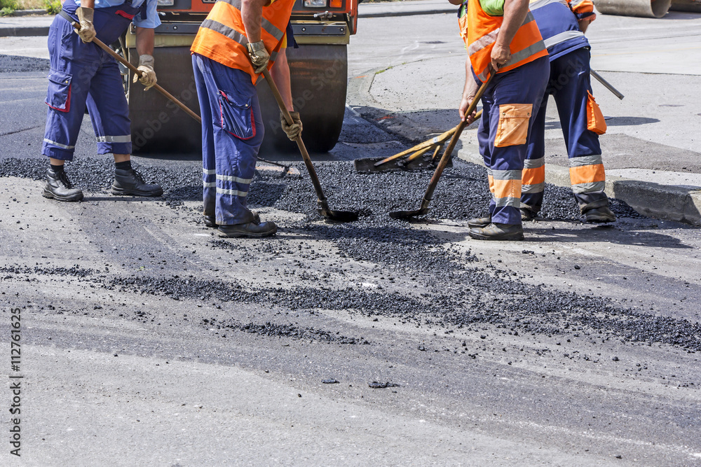 Roller and workers on asphalting and repair of city streets Roller and workers on asphalting and repair of city streets