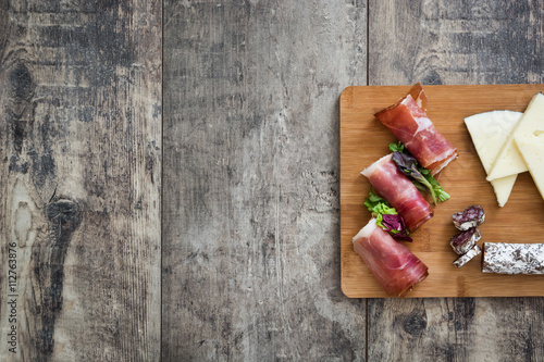 Spanish serrano ham, cheese and sausage on a rustic wooden background 